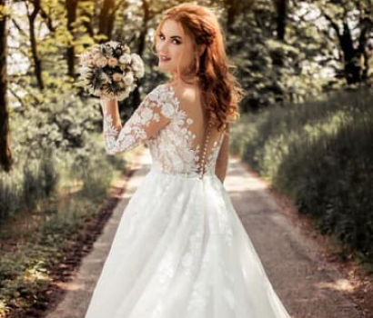 Bride in a white wedding dress walking down a path